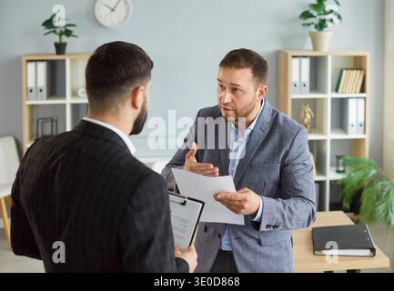 Dissatisfied business people colleagues disputing having disagreement at workplace Stock Photo
