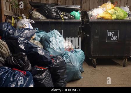 17.03.2025, Germany, Berlin, Berlin - Full garbage bags stand in front of overflowing garbage cans due to the warning strike at the BSR. 00S250317D801 Stock Photo