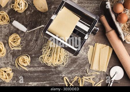 Preparing homemade fettuccine on pasta machine Stock Photo