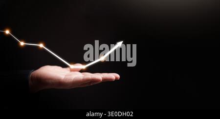 Business recovery concept. Glowing graph rising upward from a man hand. Economic rebound, financial growth, investment success, recovering stock marke Stock Photo