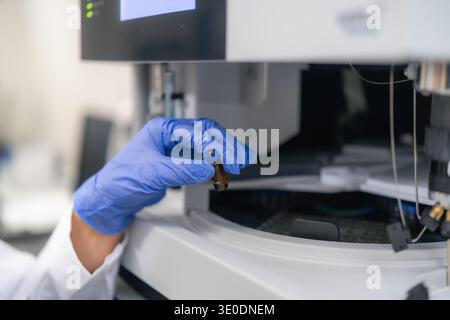 Conducting precise sample analysis using a brown vial within an advanced HPLC system. The workspace features modern equipment and digital displays, reflecting a systematic workflow. Stock Photo