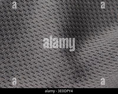 Close-up of a gray textured fabric commonly used for moisture-wicking athletic jerseys. Stock Photo