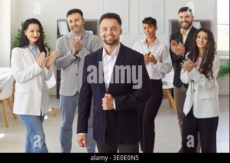 Happy young business man looking at camera and smiling in office. Leadership and success concept Stock Photo