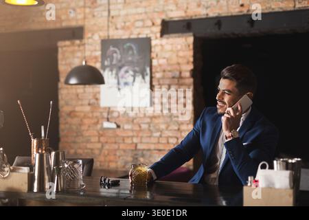 Cheerful business talking on phone in bar Stock Photo