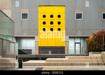 Kyoto modern building facade with bright yellow panels and circular windows Stock Photo
