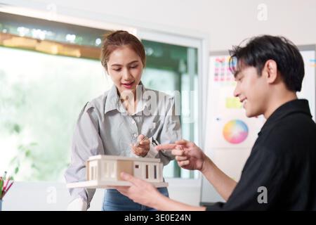 Architects Collaborating on Building Model and Design Plans Stock Photo