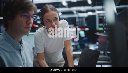 Male and Female Brokers Analyzing Real Time Stock Data Together. Two Professional Investment Experts Collaborate Closely on Trading Floor. Strategy Discussion, Data Driven Decision Making, Teamwork. Stock Photo