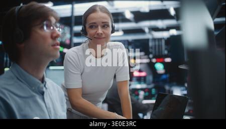 Male and Female Brokers Analyzing Real Time Stock Data Together. Two Professional Investment Experts Collaborate Closely on Trading Floor. Strategy Discussion, Data Driven Decision Making, Teamwork. Stock Photo