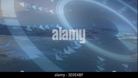 Displaying translucent HUD overlay showing rings, arrows and grid over coastal aerial landscape Stock Photo