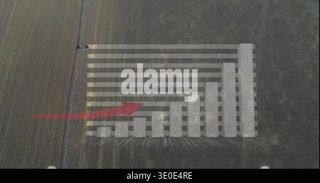 Displaying translucent bar chart with labels overlaying farm rows, with red arrow and utility pole Stock Photo