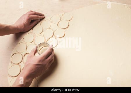Creating a Collection of Round Shapes From Dough on a Wooden Surface Stock Photo
