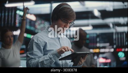 Male Financial Analyst in Blue Shirt Using Hand Gestures Execute Trades at Stock Market. Concept of Rapid Fire Decision Making Process Required in Professional Investment Banking and Asset Management. Stock Photo