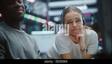 Multicultural Professional Team Reviewing Real Time Financial Indices. Serious Team of Financial Experts Scrutinizes Live Exchange Rates and Indices. High Stakes Decision Making, Analytical Research. Stock Photo