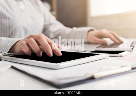 Woman working on laptop and digital tablet at office Stock Photo
