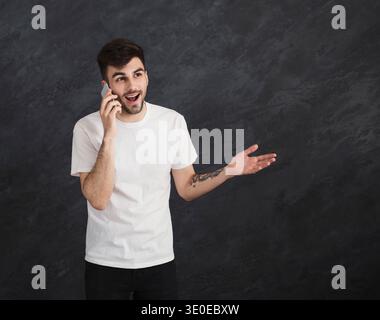 Excited man having pleasant conversation on smartphone Stock Photo