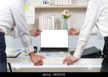 Business Presentation. Team members discussing data insights on a laptop screen during a meeting. Stock Photo