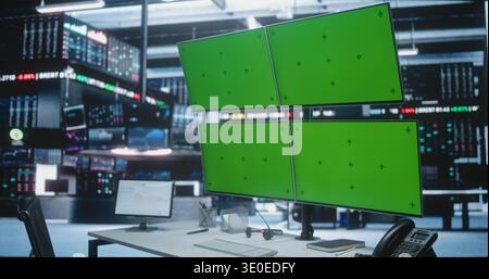 Empty Trading Desk With Green Screen Monitors in Modern Exchange Hub. Traders Workplaces With Multiple Displays Replaced Chroma Key Green Background, Positioned in Dynamic Investment Firm Environment. Stock Photo