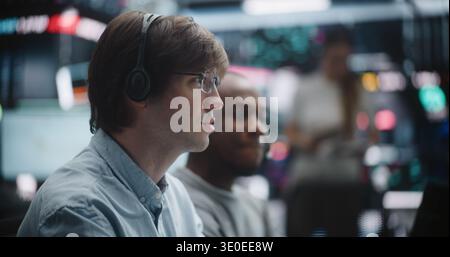 Senior Financial Advisor Evaluating Junior Analyst Practical Trading Skills. African American Senior Broker Observe Junior Specialist Working at Multi Monitor Dashboard. Professional Asset Management. Stock Photo