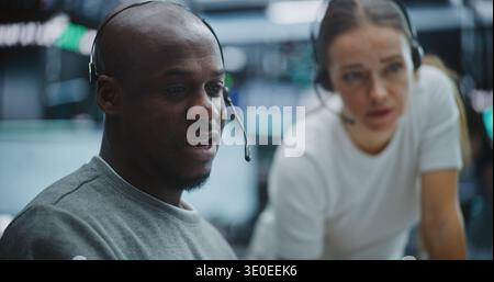 Investment Specialists Engaging in Active Brainstorming Session at Workstation. in Busy Trading Floor, Female Expert and Male Colleague Exchange Rapid Ideas. Corporate Synergy, Team Communication. Stock Photo