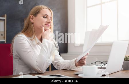 Concentrated businesswoman checking documents at office Stock Photo