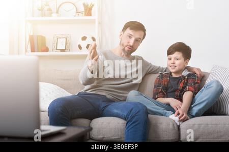 Happy father and son watching a movie on a laptop at home Stock Photo