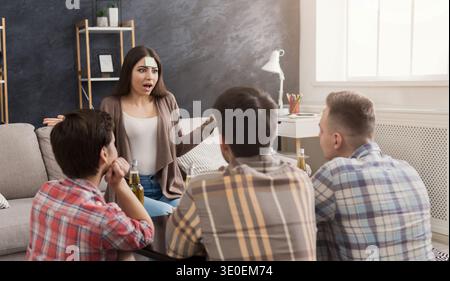 Four friends playing game guess who i am Stock Photo