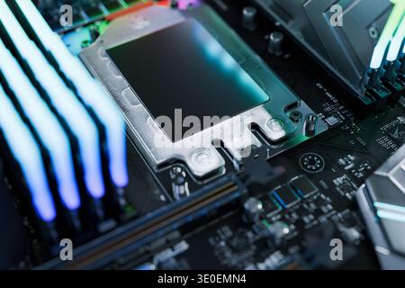 Close-up of a high-end CPU socket on a modern motherboard with vibrant RGB lighting. Professional workstation or gaming PC build featuring powerful pr Stock Photo