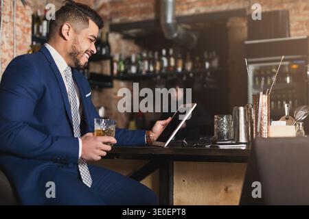 Young man sitting at bar counter and using digital tablet Stock Photo