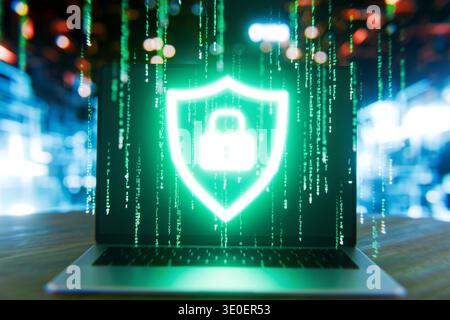 laptop screen featuring a glowing security shield and padlock icon over a green matrix digital rain, representing cyber defense, data protection, and Stock Photo