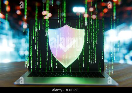 Cybersecurity concept. Laptop with a glowing digital shield and checkmark icon. Matrix-style green code falling on a screen in a blurry high-tech back Stock Photo