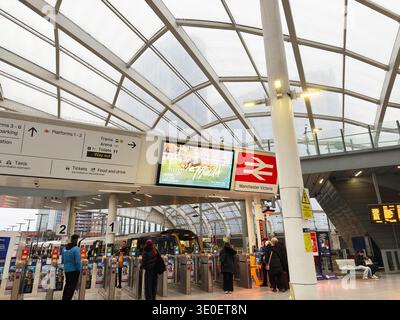 Manchester, UK - February 15, 2026: Busy interior of Manchester Victoria station showing passengers, turnstiles, trains and overhead digital signage. Stock Photo