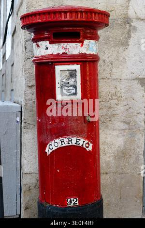 Colorful, painted, public mailbox on a sidewalk in Lisbon, Portugal with the word "correio" which translates to "mail"in Portuguese. Stock Photo