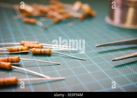 Electronic resistors and tweezers on cutting mat electronics workspace Stock Photo