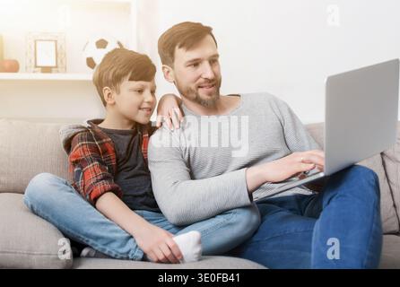 Father and son using laptop at home Stock Photo