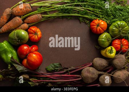 A group of fresh vegetables is placed in a circle on a wooden table. There are carrots, tomatoes, and beets. The colors are bright, indicating freshness and quality. Stock Photo
