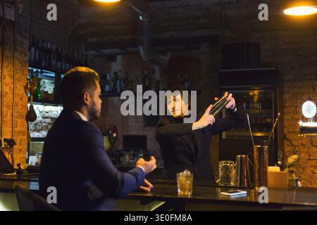 Drunk businessman talking to bartender Stock Photo
