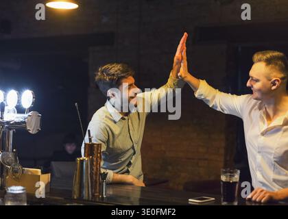 Two cheerful friends meet each other in beer pub Stock Photo