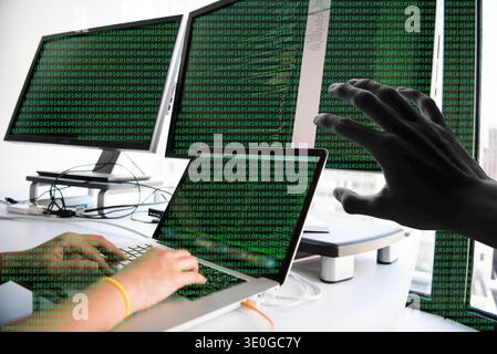 Hacker Reaching Over Laptop With Multiple Monitors Showing Green Binary Code Representing Cybersecurity Breach Stock Photo