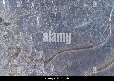 Crystalline lines tracing contours on icy surfaces. Fine melt streaks resembling contours and delicate crystalline structures on frozen icy grounds Stock Photo