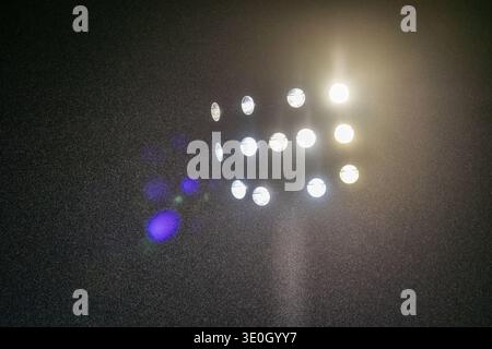 Illuminated floodlight mast in a stadium at night Stock Photo
