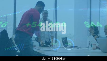 Reviewing team leaning in boardroom, man in red sweater pointing at laptop with financial overlay. Meeting, business, analytics, data, charts, graphs, Stock Photo