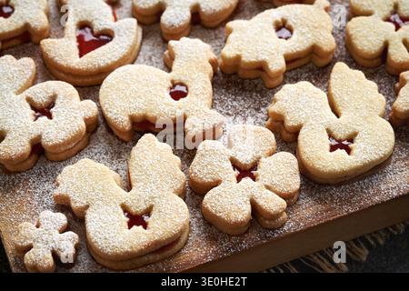 Animal shaped Linzer Easter cookies filled with strawberry marmalade and dusted with sugar on a wooden table in spring Stock Photo