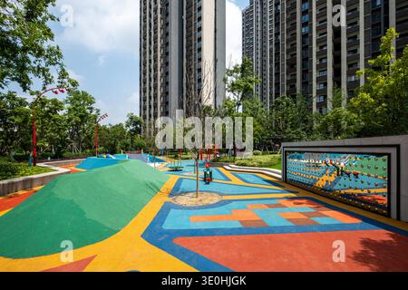 Description: A sunny day view of a playground area featuring colorful shapes and play equipment. The image conveys kids space, design, and outdoor act Stock Photo