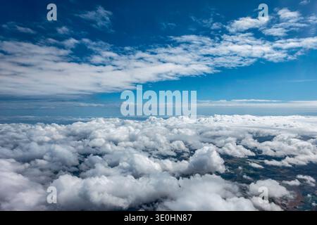 High-altitude aerial view of dense cumulus clouds over Murcia, Spain, with the Mediterranean landscape partially visible through the cloud deck. Stock Photo