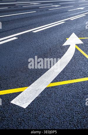 Traffic sign white arrow on the asphalt road. Arrow sign on asphalt road Stock Photo