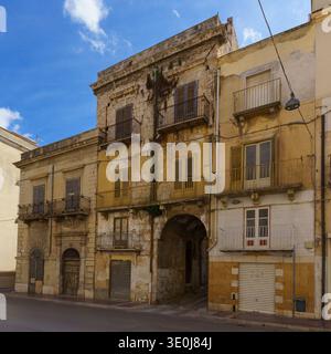a decayed but architecturally imposing historic building (likely a small palazzo) in the old town of Alcamo, Sicily. The structure features a large ce Stock Photo