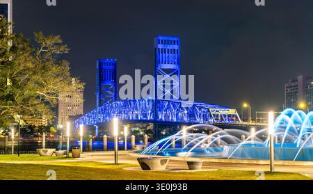 Beautiful night view of the illuminated Main Street Bridge and Friendship Fountain in downtown Jacksonville, Florida, with city lights and urban architecture. Stock Photo