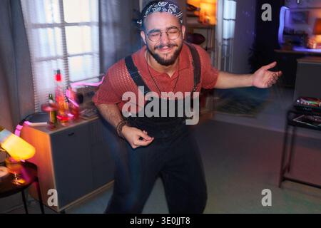 Young Man Dancing Joyfully at Home Party in Living Room Stock Photo