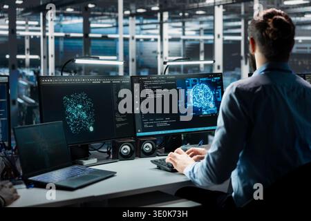 Technician working in data center with equipment managing AI training datasets. IT professional overseeing machine learning gear in server hub supporting scalable infrastructure for AI apps Stock Photo