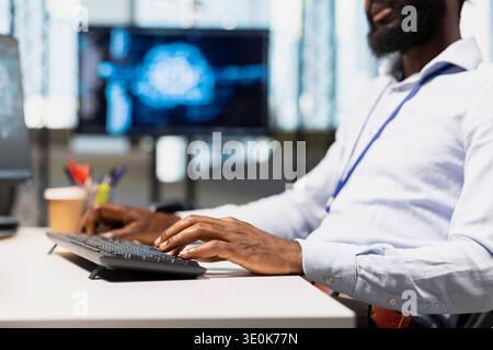Close up of programmer typing on keyboard, utilizing AI to optimize performance and forecast issues. Employee writing code in office, training machine learning models using PC Stock Photo